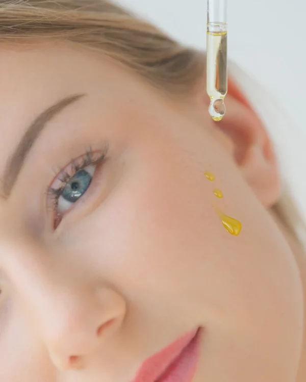 Zoe applying Sérum Radiance Aliscential to her cheek – natural Swiss face serum for luminous, hydrated skin.