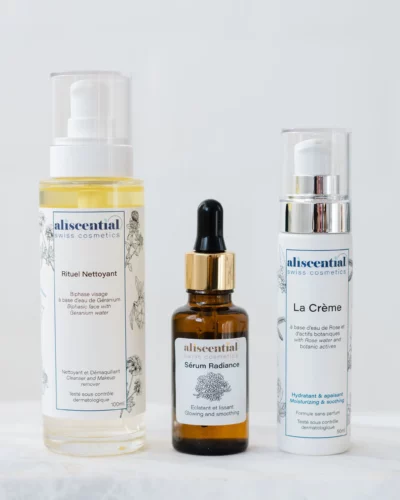Aliscential Face routine featuring 3 products — Rituel Nettoyant, Sérum Radiance and La Crème — displayed together in a natural and elegant setting.